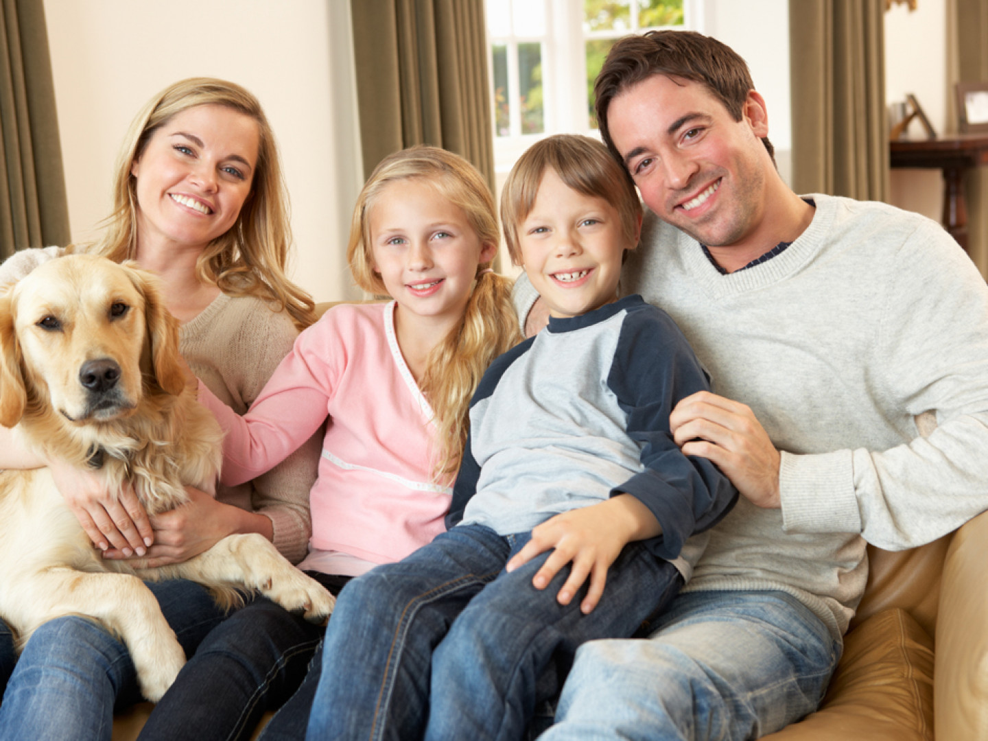 Happy-young-family-sitting-on--13921487